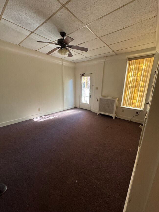 Sala de estar con vista a la puerta principal y al ventilador de techo - 151 N Hanover St