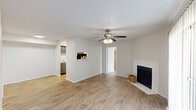 Located at 1101 N Georgetown St in Round Rock, TX, this single-story 2-bedroom, 2-bathroom home offers a functional and comfortable layout. The open living room serves as the heart of the space, showcasing wood-look flooring, a textured ceiling, and a ceiling fan. A white-surround wood-burning fireplace adds a cozy focal point, while vertical blinds covering a sliding glass door allow natural light to pour in. The living area flows seamlessly into the kitchen, which is accessible via a pass-through opening. The kitchen features gray cabinetry, a double sink, light countertops, and black appliances including a refrigerator and dishwasher. Both bedrooms are well-proportioned, with the primary bedroom offering generous space, a ceiling fan, and access to a walk-in closet. The second bedroom also includes a ceiling fan and a window for natural light. Each of the two bathrooms is equipped with a full tub-shower combination featuring white tile surround and chrome fixtures. Additional highlights include two closets, a dedicated laundry area, and consistent wood-look flooring throughout the home, creating a cohesive and easy-to-maintain interior.