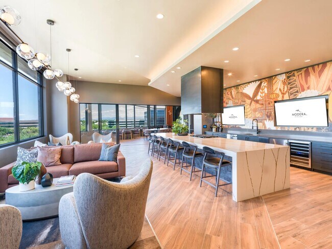 Reciba invitados o relájese en la cocina y el salón de demostración bellamente diseñados, que cuentan con acabados modernos, amplios asientos y pantallas de entretenimiento integradas. - Modera Reserve