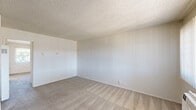 Located at 713 E Travis in Fairfield, CA, this one-bedroom, one-bathroom unit offers a practical and well-organized single-floor layout. The living room features neutral carpet, textured ceilings, and a window dressed with vertical blinds that bring in natural light and outdoor views, creating a bright and open atmosphere. The galley-style kitchen is efficiently designed with white cabinetry, granite-style countertops, a gas range, a full-size refrigerator, and wood-look vinyl flooring that adds warmth and durability. The spacious bedroom comfortably accommodates furnishings and includes a sliding-door closet for ample storage. A dedicated vanity area with a granite-style countertop and mirrored medicine cabinet is conveniently situated adjacent to the bedroom, leading into the full bathroom complete with a tiled shower-tub combination. Throughout the unit, the consistent use of neutral tones, textured ceilings, and clean finishes creates a cohesive and functional living environment suitable for comfortable everyday living.