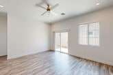 Located in Phoenix, AZ, this thoughtfully designed single-story home offers three bedrooms and four bathrooms across a well-proportioned floor plan. The interior showcases a clean, modern aesthetic throughout, with crisp white walls, wood-look flooring, and an abundance of natural light in every room.

The open-concept kitchen and living area serves as the heart of the home. The kitchen is outfitted with white shaker cabinetry, a subway tile backsplash, quartz countertops, stainless steel appliances including a refrigerator, range, microwave, and dishwasher, and a central island ideal for dining or meal prep. The adjoining living area features a ceiling fan and sliding glass doors that open to the backyard, creating a seamless indoor-outdoor flow.

The generously sized primary bedroom includes its own sliding glass door to the exterior, a ceiling fan, and an en suite bathroom with a walk-in glass shower, dual vanity with quartz countertops, and hardwood-style flooring. Additional bedrooms are bright and well-lit, benefiting from large windows with views of the surrounding neighborhood. Two closets and four full bathrooms provide ample storage and convenience throughout. The home's clean, neutral palette and modern finishes create a cohesive and inviting atmosphere.