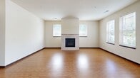This well-appointed single-floor home in Brookfield, Wisconsin offers three bedrooms, two full bathrooms, and a thoughtfully designed layout. The open kitchen is a standout feature, showcasing rich medium-toned wood cabinetry, granite countertops, a granite-topped island with pendant lighting, and a full suite of stainless steel appliances including a refrigerator, range, microwave, and dishwasher. Durable hardwood-style flooring runs throughout the kitchen and flows into the living room, which is anchored by a tile-surround fireplace flanked by windows that bring in natural light and outdoor greenery views. The three bedrooms offer plush carpeting and windows overlooking lush surroundings, providing comfortable, quiet retreats. The primary bathroom features large-format tile flooring, warm wood cabinetry with granite counters, a framed mirror, and a walk-in glass-door shower. The second full bathroom mirrors this quality with similar finishes and includes a shower-tub combination. A hallway with a closet adds practical storage. The home's neutral color palette of warm beige tones, consistent trim work, and quality finishes throughout give the space a cohesive and inviting character suited for comfortable everyday living.