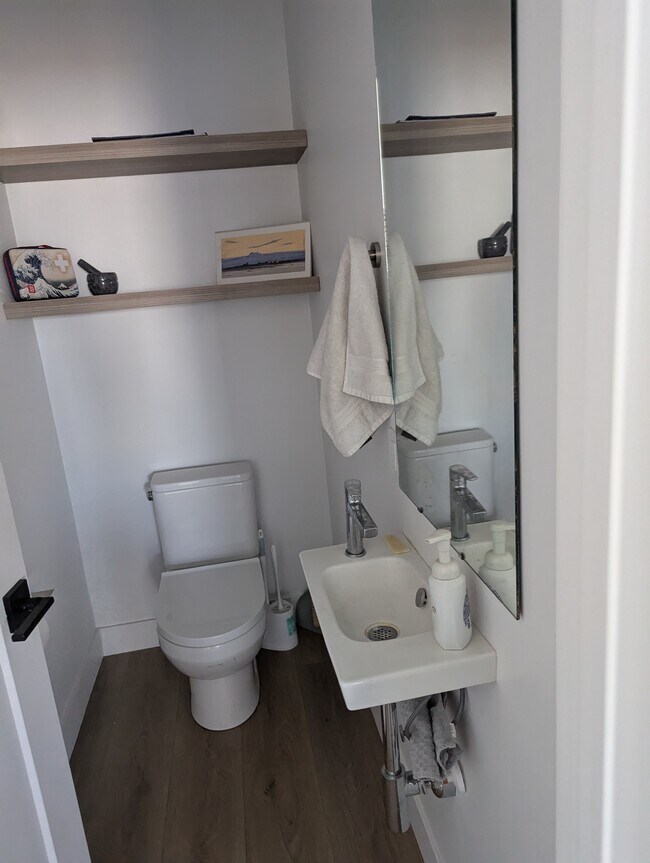 Medio baño con pisos de madera y sanitario. - 44 W Iko Ave