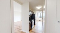 This well-appointed 1-bedroom, 1-bathroom residence at 380 Prospect Ave in Hackensack, NJ offers a thoughtfully designed layout across a single floor. Light-toned hardwood-style flooring flows throughout, lending a clean and cohesive look to every room. The open living and dining area is a standout space, bathed in natural light through large windows and sliding glass doors that lead to a private patio, offering expansive views of the surrounding landscape. The galley-style kitchen is efficiently laid out with dark cabinetry, stainless steel appliances including a gas range, microwave, dishwasher, and refrigerator, complemented by a stainless steel sink. A hallway connects the main living areas to the generously sized bedroom, which features large windows framing scenic outdoor views, built-in white bi-fold closets providing ample storage, and access to additional closet space. The bathroom is finished with classic square tile walls, mosaic tile flooring in warm yellow tones, a full tub-shower combination, and a white vanity. With four closets total throughout the unit, storage is plentiful. The overall ambiance is bright, clean, and move-in ready.