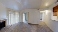 Located at 2626 Thousand Oaks Dr in San Antonio, TX, this 2-bedroom, 1-bathroom single-floor unit offers a well-organized and functional layout. The living room is a standout space, featuring vaulted ceilings that lend an open, airy feel, soft carpeting underfoot, and a classic brick fireplace framed by a white mantel — creating a warm and inviting focal point. Vertical blinds cover a large sliding door, allowing natural light to filter through. The adjacent dining area features warm hardwood-style flooring and a pendant light fixture, with a window offering a view of the greenery outside. The galley-style kitchen is efficiently designed with rich wood cabinetry, light countertops, a double sink, and black appliances including a refrigerator, range, and built-in microwave. A hallway connects the living areas to the two carpeted bedrooms, each offering natural light through windowed blinds and a comfortable, quiet atmosphere. The bathroom is clean and practical, featuring wood vanity cabinetry, a light countertop, and a shower/tub combination. A dedicated closet and hallway complete the layout, making this a well-appointed and efficient home.