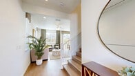 Located in Manteca, California, this well-appointed two-story home offers three bedrooms, four bathrooms, and a thoughtfully designed layout spread across two floors. The ground floor provides a welcoming entry point with access to an attached garage featuring a motorized door and overhead lighting, alongside a clean half-bath with a modern pedestal sink and oval mirror. The main living area flows seamlessly from the bright, open kitchen — outfitted with white shaker cabinetry, quartz countertops, a central island, stainless steel appliances, and pendant lighting — into the living room, which features warm hardwood-style flooring, a ceiling fan, and natural light from strategically placed windows. Upstairs, the spacious primary bedroom is carpeted, ceiling fan-equipped, and bathed in natural light through multiple windows, complemented by a walk-in closet with built-in shelving rods. The secondary bedrooms are equally comfortable, with soft carpet, natural light, and neutral tones. A dedicated laundry room on the upper level includes side-by-side washer and dryer units with upper cabinetry for storage. The bathrooms throughout are finished with light tile flooring and clean, minimal fixtures. The overall aesthetic is modern and cohesive, with a neutral color palette and quality finishes throughout.