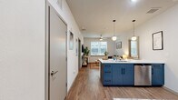 Located at 404 Harvey Mitchell Pkwy in College Station, this thoughtfully designed 2-bedroom, 2-bathroom residence offers a contemporary open-concept layout with cohesive modern finishes throughout. Wood-look flooring flows seamlessly across the entire unit, connecting each space with warmth and consistency.

The kitchen serves as a central focal point, showcasing bold navy cabinetry, a large island with a white countertop and bar seating, stainless steel appliances, and stylish globe pendant lighting. The adjacent living room benefits from a large window that invites natural light and features a ceiling fan overhead.

Each bedroom is a private, comfortable retreat with its own natural light from dedicated windows. Both bedrooms connect directly to their own private bathrooms, which are outfitted with matching navy vanities, white countertops, tiled shower stalls with curtains, and ceiling fans. The unit includes three closets, one of which is a spacious walk-in with wrap-around shelving and hanging rods, providing generous storage.

The clean, neutral color palette of white walls combined with navy accents creates a modern, cohesive aesthetic throughout the unit, making it a functional and stylish living space well-suited for residents in the College Station area.