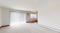 Located at 9850 Excelsior Blvd in Hopkins, MN, this 2-bedroom, 1-bathroom residence offers a practical and comfortable single-floor layout. The living room is a bright, open space featuring plush carpeting, a ceiling fan, baseboard heating, and large vertical-blind-covered sliding doors that invite natural light and provide outdoor views. The kitchen is well-appointed with warm wood cabinetry, granite-style countertops, tile flooring, stainless steel appliances including a range, microwave, refrigerator, and a double sink — offering ample storage and counter space for everyday use. Both bedrooms are carpeted and finished with warm wood baseboards and trim. The spacious primary bedroom includes its own closet and baseboard heating, while the second bedroom features a window with outdoor views and a ceiling light fixture. Each bedroom benefits from dedicated closet space, and the unit includes a total of four closets for excellent storage. The bathroom is finished with stone-patterned tile flooring and features a full tub-shower combination and a white vanity. Two hallways connect the rooms, creating a smooth and logical flow throughout the residence. Ceiling fans in the main living areas add to the overall comfort of the space.