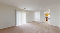 Located at 9713 Queen Anne's Lace in Laurel, MD, this single-floor, 2-bedroom, 2-bathroom residence offers a well-organized layout designed for comfortable everyday living. The open living room is generously sized, featuring plush wall-to-wall carpeting, recessed lighting, and a large sliding glass door dressed with vertical blinds that allows natural light to fill the space. The kitchen sits adjacent to the living area and is equipped with warm honey-toned wood cabinetry, dark granite-style countertops, a stainless steel sink, and white appliances including an electric range and refrigerator — all set on easy-care tile flooring. A dedicated pantry provides additional storage convenience. The carpeted primary bedroom is a spacious retreat with a natural light window and direct access to a walk-in closet with a full hanging rod. The second bedroom is also well-proportioned with carpeting and a window. Both bathrooms feature wood-tone vanities and tub/shower combinations, with the full bath showcasing classic multi-tone mosaic tile flooring. A hallway connects all rooms efficiently, and the home also includes a dedicated laundry area and utility room, rounding out a thoughtfully complete floor plan.