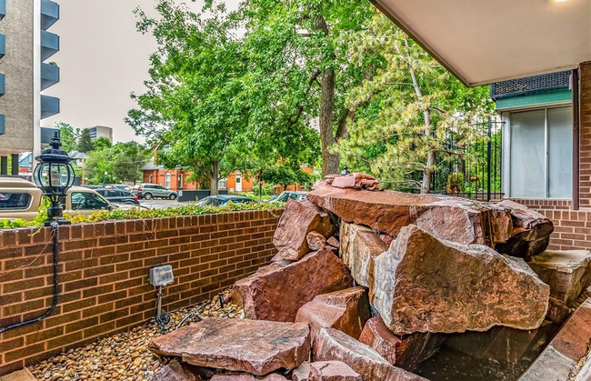 The entryway features a striking xeriscaped design with vibrant red rock landscaping - 1200 Vine St