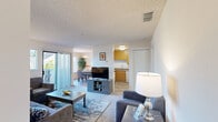 Located at 2851 Redwood Parkway in Vallejo, CA, this one-bedroom, one-bathroom residence offers a thoughtfully designed single-floor layout that maximizes every square foot. The entrance opens into a comfortable living room featuring plush carpeting, neutral walls, and a sliding glass door that leads to a private balcony — allowing natural light to fill the space and providing pleasant outdoor views. The living area flows seamlessly into a dedicated dining room, highlighted by a statement chandelier, wood-look flooring, and a large window that brings in additional natural light. The kitchen is equipped with warm wood cabinetry, stone-look countertops, a full-size refrigerator, dishwasher, and a sink with a window view. An in-unit laundry area adds everyday convenience. The carpeted bedroom is generously proportioned, featuring a sliding glass door to a private balcony, two closets, and a wall mirror that enhances the sense of space. The full bathroom includes a single vanity with stone-look countertop, warm wood cabinetry, and a shower/tub combination. Throughout the home, textured ceilings and a clean, neutral palette create a bright and functional living environment.
