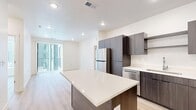 Located at 2459 Quincy Ave in Ogden, Utah, this modern 2-bedroom, 2-bathroom unit offers a thoughtfully designed single-floor layout with contemporary finishes throughout. Light-toned hardwood-style flooring flows seamlessly through every room, creating a cohesive and clean aesthetic.

The open-concept kitchen, dining, and living area serves as the heart of the space. The kitchen is outfitted with dark wood cabinetry, white quartz countertops, a central island, and a full suite of stainless steel appliances including a refrigerator, dishwasher, microwave, and range. Recessed lighting illuminates the space, which opens directly into the living and dining area — ideal for entertaining.

Both bedrooms are bright and well-proportioned, featuring large windows that invite natural light and offer exterior views. The primary bedroom includes a ceiling fan and dedicated closet. Each bathroom is finished with dark wood vanities, white quartz countertops, large mirrors, and tub-shower combinations, maintaining the unit's consistent modern style.

A dedicated in-unit laundry area houses a full-size stacked washer and dryer, adding everyday convenience. Two closets provide ample storage throughout. Clean white walls, recessed lighting, and consistent flooring tie the entire space together with a bright, modern sensibility.