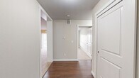 Located at 5501 Prefontaine Ave in Regina, Saskatchewan, this single-floor unit offers a practical and well-organized layout accommodating four bedrooms and one bathroom. The entryway features rich dark hardwood flooring that flows through the hallway and kitchen, creating a warm contrast against the neutral, light-toned walls throughout.

The kitchen is a standout space, outfitted with crisp white cabinetry, dark granite-style countertops, and black appliances including a refrigerator, electric range, microwave, and oven. A peninsula with a built-in sink adds additional workspace and a natural boundary between the kitchen and the adjoining living area.

The living room is bright and inviting, with plush carpet, a wall-mounted air conditioning unit, baseboard heating, and a sliding glass door that opens to a balcony with views of the surrounding neighbourhood. The bedrooms are carpeted and neutrally finished, each offering sliding double-door closets and baseboard heating. Windows in the bedrooms allow natural light and outward views of the streetscape.

The bathroom features a full-sized soaker tub and shower combo with clean white surround. Throughout the unit, white panel doors and consistent neutral tones contribute to a cohesive, understated aesthetic suited for comfortable everyday living.
