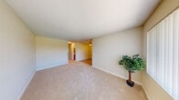 Located at 9585 Gold Coast Dr in San Diego, CA, this two-bedroom, one-bathroom unit offers a practical and well-organized single-floor layout. The living area features neutral-toned carpet and warm beige walls, creating a clean and inviting atmosphere. Large windows dressed with vertical blinds allow ample natural light to flow throughout the space.

The kitchen is outfitted with warm wood cabinetry, stainless steel appliances including a refrigerator, microwave, and electric range, and light wood flooring that adds a touch of warmth. A breakfast bar provides a convenient spot for casual dining.

Both bedrooms are carpeted and share a similar aesthetic with neutral walls and vertical-blind windows. The primary bedroom includes a sliding mirrored closet for storage and convenient access to the bathroom. The second bedroom also features a mirrored closet, maximizing storage efficiency.

The bathroom is functional and straightforward, featuring a full tub-shower combination with a curtain enclosure, a toilet, and warm-toned walls. A hallway connects the main living areas to the bedrooms and bathroom, contributing to a logical and efficient flow throughout the unit.