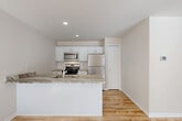 Located at 7699 Shaw Ln in Canton, Michigan, this two-story home offers three bedrooms, three bathrooms, and a well-designed layout spread across two floors. The main level features an open-concept kitchen and living area bathed in natural light from multiple windows and a sliding glass door. The kitchen is outfitted with crisp white cabinetry, a subway tile backsplash, granite-style countertops with a breakfast bar peninsula, and a full suite of stainless steel appliances including a gas range, built-in microwave, and refrigerator. A pantry provides additional storage. The living area features light hardwood-style flooring that flows throughout the main level. Upstairs, the spacious primary bedroom includes generous closet space, while all bedrooms are finished with plush carpeting and large windows offering neighborhood views. The bathrooms are well-appointed, highlighted by a stunning walk-in shower clad in full marble-look tile with a glass enclosure. This home also includes a dedicated laundry room with a full-size washer and dryer, seven closets for abundant storage, a utility room, and an attached garage with direct interior access. The neutral, modern finishes throughout create a clean and welcoming ambiance.