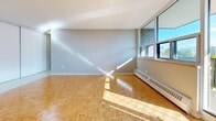 Located at 6040 Bathurst Street in Toronto's North York neighborhood, this well-appointed one-bedroom, one-bathroom unit offers a functional and comfortable layout across a single floor. The living room is a standout feature, showcasing classic parquet hardwood flooring that extends throughout the space, neutral grey walls, and large floor-to-ceiling windows that bathe the room in natural light and frame open city views. A sliding door leads directly to the private balcony, extending the living area outdoors. The kitchen is thoughtfully designed with crisp white cabinetry, a white tile backsplash, light stone countertops, and stainless steel appliances, including a freestanding range with overhead ventilation. Tile flooring completes the kitchen's clean, modern aesthetic. The spacious primary bedroom features the same warm parquet flooring, a large sliding-door closet, and a window overlooking the surrounding neighborhood. An additional closet provides generous storage near the entrance. The bathroom is finished with a full soaker tub surrounded by clean white subway-style tile. Baseboard heating is present throughout, ensuring comfort year-round. The unit also includes a welcoming entrance foyer that connects seamlessly to the main living areas.