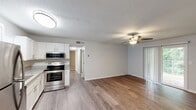 Located on Third St NE in Alabaster, Alabama, this single-floor home offers a well-organized layout with a comfortable, move-in-ready feel. The open-concept living and dining area is finished with durable wood-look flooring and neutral gray walls, creating a bright and airy atmosphere. A ceiling fan with a light kit keeps the space comfortable, while a sliding glass door with vertical blinds provides natural light and outdoor access. The kitchen is a functional highlight, featuring white cabinetry, granite countertops, stainless steel appliances including a refrigerator, dishwasher, and electric range, along with a stainless steel sink beneath a window. The bedrooms are carpeted for warmth and comfort, each equipped with a ceiling fan and windows that bring in natural light and views of the surrounding greenery. The bathroom is clean and efficient, with a shower/tub combo and wood-look flooring that ties the space together. A textured ceiling is present throughout the common areas, adding a classic residential touch. The overall design is practical and well-maintained, making this Alabaster home a welcoming and functional living space.