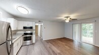 Located on Third St NE in Alabaster, Alabama, this single-floor home offers a well-organized layout with a comfortable, move-in-ready feel. The open-concept living and dining area is finished with durable wood-look flooring and neutral gray walls, creating a bright and airy atmosphere. A ceiling fan with a light kit keeps the space comfortable, while a sliding glass door with vertical blinds provides natural light and outdoor access. The kitchen is a functional highlight, featuring white cabinetry, granite countertops, stainless steel appliances including a refrigerator, dishwasher, and electric range, along with a stainless steel sink beneath a window. The bedrooms are carpeted for warmth and comfort, each equipped with a ceiling fan and windows that bring in natural light and views of the surrounding greenery. The bathroom is clean and efficient, with a shower/tub combo and wood-look flooring that ties the space together. A textured ceiling is present throughout the common areas, adding a classic residential touch. The overall design is practical and well-maintained, making this Alabaster home a welcoming and functional living space.