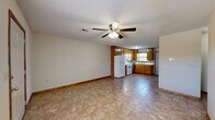 Located at 1258 E Allen Rd in Tahlequah, Oklahoma, this single-story 2-bedroom, 1-bathroom home offers a practical and well-organized layout. The open-concept living area flows directly into the kitchen, creating a cohesive shared space. Tile flooring runs throughout the main living and kitchen areas, while a ceiling fan with light fixture adds comfort and functionality to the living room, which also features a textured ceiling.

The kitchen is well-equipped, featuring warm honey-toned oak cabinetry that extends from floor to ceiling, providing generous storage. White appliances include a refrigerator, range, and a stainless steel dishwasher. A double-basin sink sits beneath a window that allows natural light into the space, and ample counter space makes the kitchen highly functional.

Both bedrooms are carpeted and include closets, with one bedroom featuring a window with outdoor views. The full bathroom includes a wood-toned vanity with overhead cabinetry, a toilet, and a tub-shower combination. A dedicated laundry area accommodates a full-size washer and dryer and includes a wooden overhead shelf for additional storage. Consistent wood trim and neutral wall tones throughout lend the home a cohesive, understated character.