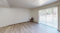 Located at 1324 Lafayette Ave in Kalamazoo, Michigan, this two-bedroom, one-bathroom single-floor residence offers a clean, functional layout with a bright and neutral aesthetic throughout. The combined living and dining area serves as the heart of the home, featuring light wood-style flooring, baseboard heating, a wall-mounted air conditioning unit, and a sliding glass door that fills the space with natural light and provides access to the outdoors. The kitchen is efficiently designed with dark cabinetry, granite-style countertops, stainless steel appliances including a refrigerator and dishwasher, and matching light flooring that ties the common areas together. A central hallway connects the main living spaces to the private quarters, lined with an impressive five closets for generous storage. Both bedrooms are carpeted and share a similarly clean, neutral palette, each equipped with closet space and baseboard heating. The primary bedroom is a comfortable size with a double closet. The full bathroom features a vanity with a dark countertop, tile surround, a bathtub, and wood-style flooring. The overall ambiance is light, practical, and move-in ready.