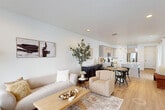 This thoughtfully designed two-story home offers a functional and stylish layout across two well-proportioned floors. The main level welcomes you with a bright, open-concept living, dining, and kitchen area bathed in natural light from large windows. The kitchen is a standout feature, showcasing light wood cabinetry, white quartz countertops, stainless steel appliances, a spacious island with pendant lighting, and light hardwood flooring that flows seamlessly throughout the main level. The living area is warm and inviting, complemented by recessed lighting and a neutral, modern aesthetic.

Upstairs, the home includes four bedrooms and three bathrooms. The generously sized primary bedroom features its own ensuite bathroom and a well-organized walk-in closet with built-in shelving and hanging rails. Additional bedrooms are carpeted and include closet space, while a dedicated office provides a quiet, functional workspace with natural light. The three bathrooms are finished with clean, contemporary fixtures, including a bathroom featuring light wood-toned cabinetry and a walk-in shower. Hallways and staircases connect both floors efficiently, and dual entrances add convenience. The overall ambiance is modern, light, and neutral throughout.