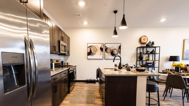 Gourmet kitchen featuring premium full-size Stainless Steel ENERGY STAR® kitchen appliances including oven range, microwave, dishwasher, garbage disposal, and refrigerator with ice maker. - Industrie Apartments