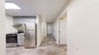 This 2-bedroom, 1-bathroom residence in Everett, Washington offers a clean, modern layout designed for comfortable everyday living. The interior features a consistent palette of neutral tones, white trim, and crisp finishes throughout, creating a bright and cohesive atmosphere.

The kitchen is equipped with stainless steel appliances, including a full-size refrigerator and range, complemented by gray shaker-style cabinetry that extends to the upper walls for generous storage. Wood-look luxury vinyl plank flooring runs through the kitchen and hallway, offering both durability and a contemporary aesthetic.

A central hallway connects the main living areas and provides access to two dedicated closet spaces, adding practical storage to the layout. Both bedrooms are carpeted in a neutral tone and feature windows overlooking lush greenery, filling each room with natural light. The primary bedroom includes a built-in double closet, offering ample wardrobe space.

The full bathroom is finished with wood-look vinyl flooring, a gray vanity with a white countertop, a tub-shower combination, and clean white walls that contribute to a fresh, polished look.

Overall, this residence presents a well-maintained, move-in ready space with functional design and tasteful finishes throughout, situated conveniently in the Everett, WA area.