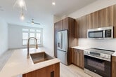Located at 333 W 24th St in Houston's desirable Timbergrove neighborhood, this well-designed 2-bedroom, 1-bathroom unit offers a clean, modern aesthetic throughout its efficiently arranged single-floor layout. Light wood flooring flows seamlessly through the open living areas, complemented by crisp white walls and abundant natural light.

The open-concept kitchen is a standout feature, boasting white shaker cabinetry extending to the ceiling, a light blue subway tile backsplash, quartz countertops, and a large center island with a farmhouse sink and pendant lighting above. Stainless steel appliances — including a French door refrigerator, range, microwave, and dishwasher — complete this functional and stylish space. The kitchen opens directly into the living area, which features French doors with transom windows that invite natural light and provide outdoor access.

Both bedrooms are bright and calm, featuring light wood flooring, white walls, and multiple windows with blinds that offer neighborhood views. The primary bedroom provides a comfortable footprint with easy access to the shared bathroom.

The bathroom is elegantly appointed with large-format marble-look tile flooring, a wide double-sink vanity with a backlit mirror, a glass-enclosed shower, and access to a dedicated closet with built-in shelving. Paneled interior doors and recessed lighting add refined finishing touches throughout.