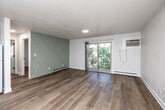 Located at 3621 Merle Hay Rd in Des Moines, Iowa, this 2-bedroom, 1-bathroom unit offers a thoughtfully updated interior with a clean, modern aesthetic throughout. Light-toned hardwood-style flooring runs continuously across the entire unit, creating a cohesive and bright atmosphere in every room.

The living room serves as the central gathering space, highlighted by a distinctive geometric sage-green accent wall that adds character and visual interest. A sliding glass door floods the room with natural light and provides direct access to a private balcony with views of surrounding trees. A wall-mounted air conditioning unit and baseboard heating ensure year-round comfort.

The kitchen features gray shaker-style cabinetry, dark countertops, white subway tile backsplash, and white appliances, offering a functional and stylish cooking space that opens to the main living area.

Both bedrooms are well-proportioned and finished with the same warm flooring and crisp white walls. Each bedroom includes its own dedicated closet, providing ample storage. The primary bedroom features a walk-in closet and a window that brings in natural light.

The bathroom is clean and functional, featuring a full tub-shower combo with chrome fixtures and classic beadboard-style wall paneling. Two additional closets throughout the unit offer convenient storage solutions.