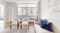 Located at 8 Park Vista in Toronto's east end, this thoughtfully designed 3-bedroom, 1-bathroom unit offers a clean, modern aesthetic across a well-utilized single floor. Light hardwood flooring runs continuously throughout, lending warmth and visual cohesion to every room.

The open-concept kitchen features two-tone cabinetry — warm wood lower cabinets paired with crisp white uppers — along with a kitchen island with bar seating, stainless steel appliances including a dishwasher and range, and a bright white countertop. The kitchen flows seamlessly into the living and dining areas, making the space feel open and connected.

The living room is bright and airy, with large windows framing leafy outdoor views that bring natural light deep into the space. A second living area provides added flexibility for lounging or relaxing.

The primary bedroom is generously sized, featuring large windows with treetop views, a built-in sliding door closet, and warm hardwood flooring. The additional bedrooms are well-proportioned, each with windows that let in ample natural light. One bedroom includes oversized floor-to-ceiling windows overlooking the surrounding greenery.

The bathroom is finished in a clean, modern style with white subway tile surrounding the bathtub, matte black fixtures, and a minimalist design. A hallway connects the main living areas to the bedrooms, providing a logical and practical layout throughout.