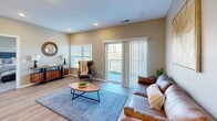 Located at 3955 Superior Dr NW in Rochester, Minnesota, this single-floor residence offers a thoughtfully designed open-concept layout with contemporary finishes throughout. The kitchen is a standout feature, equipped with stainless steel appliances, crisp white shaker cabinetry, a classic subway tile backsplash, and a large center island with a built-in sink and pendant lighting overhead — available in both gray and blue island colorways depending on the unit. Light wood-look flooring runs through the main living areas, contributing to a clean, modern aesthetic. The living room is bright and welcoming, with recessed lighting, a large window, and a sliding glass door that opens to a private balcony with outdoor views. The bedrooms are carpeted and comfortably sized, each featuring windows that allow natural light to fill the space. One bedroom includes wall-mounted sconce lighting and a rustic wood headboard wall, adding a warm, cozy character. The bathroom is well-appointed with wood-look flooring, a single-sink vanity with white countertops, and a shower-tub combination. Throughout the space, neutral warm-toned walls create a cohesive and inviting atmosphere that complements the modern design elements.