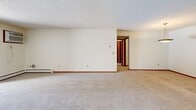 Located in Maple Grove, Minnesota, this single-floor, two-bedroom, two-bathroom residence offers a practical and comfortable layout. The open combined living and dining area is generously proportioned, featuring plush carpeting, textured ceilings, and baseboard heating throughout. A sliding glass door fills the space with natural light and provides direct access to a private patio. The kitchen is efficiently designed with warm oak cabinetry, stainless steel appliances including a refrigerator, electric range, and dishwasher, complemented by tile flooring and ample counter space. The primary bedroom is a comfortable retreat, featuring a ceiling fan, a large sliding-door closet, and a window with outdoor views, with an adjacent private bathroom. The second bedroom mirrors this layout with its own ceiling fan, carpeting, and natural light. Both bathrooms are well-appointed, featuring oak vanities with solid countertops, tile flooring, and a tub-shower combination with white tile surround. Four closets throughout the residence provide generous storage capacity. The warm wood trim accents add a cohesive, classic touch throughout the entire space.