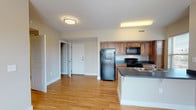 This single-floor apartment at Parkside Apartments offers a practical and comfortable layout designed for everyday living. The open-concept living area is a highlight, featuring warm hardwood-style flooring that extends throughout the main living spaces, neutral-toned walls, and a ceiling fan that adds both style and airflow. Large windows invite generous natural light, creating a bright and welcoming atmosphere.

The kitchen is well-equipped with warm wood cabinetry, dark countertops, and a full suite of black appliances including a refrigerator, range, and over-the-range microwave. A peninsula with an integrated sink adds additional counter space and allows for convenient interaction between the kitchen and living area.

The bedrooms feature plush carpeting and include spacious closets with built-in hanging rods, providing ample storage. Neutral wall tones throughout the bedrooms contribute to a calm and restful environment.

The bathroom is finished with light tile flooring, a wooden vanity with storage drawers, and clean, understated fixtures. The layout is functional and straightforward. Overall, this apartment offers a cohesive, move-in-ready living environment with consistent finishes and a clean, modern aesthetic throughout.