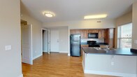 This single-floor apartment at Parkside Apartments offers a practical and comfortable layout designed for everyday living. The open-concept living area is a highlight, featuring warm hardwood-style flooring that extends throughout the main living spaces, neutral-toned walls, and a ceiling fan that adds both style and airflow. Large windows invite generous natural light, creating a bright and welcoming atmosphere.

The kitchen is well-equipped with warm wood cabinetry, dark countertops, and a full suite of black appliances including a refrigerator, range, and over-the-range microwave. A peninsula with an integrated sink adds additional counter space and allows for convenient interaction between the kitchen and living area.

The bedrooms feature plush carpeting and include spacious closets with built-in hanging rods, providing ample storage. Neutral wall tones throughout the bedrooms contribute to a calm and restful environment.

The bathroom is finished with light tile flooring, a wooden vanity with storage drawers, and clean, understated fixtures. The layout is functional and straightforward. Overall, this apartment offers a cohesive, move-in-ready living environment with consistent finishes and a clean, modern aesthetic throughout.