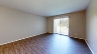 Located at 3745 Camelot Dr in Lexington, Kentucky, this single-floor, 2-bedroom, 1-bathroom home offers a practical and well-appointed layout. The living room is a comfortable, open space featuring durable hardwood-style flooring and a large sliding glass door that fills the room with natural light and provides outdoor views. A chandelier-lit hallway connects the main living areas, adding a touch of elegance to the interior.

The kitchen is thoughtfully designed with white shaker-style cabinetry, granite countertops, and black appliances including a range and refrigerator, all set atop hardwood-style flooring that continues from the living area. The space offers ample cabinetry for storage and a clean, functional workspace.

Both bedrooms are carpeted and finished with neutral gray walls, creating a calm and restful atmosphere. Each bedroom is equipped with a bi-fold closet, and windows allow natural light to brighten each room. The primary bedroom offers a comfortable amount of space with a dedicated closet.

The bathroom features a granite-topped vanity with a gray cabinet base, a lighted mirror, and hardwood-style flooring, maintaining a consistent and cohesive aesthetic throughout the home. Two hallways connect the rooms efficiently, completing this well-organized and move-in ready home.