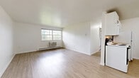Located at 4721 Wilmington Pike in Kettering, Ohio, this one-bedroom, one-bathroom unit offers a well-organized, single-floor layout designed for comfortable everyday living. The combined kitchen and living area provides an open, airy atmosphere, with crisp white walls and light wood-look flooring that reflect natural light throughout. A bold navy entry door adds a distinctive touch to the living space.

The kitchen is efficiently arranged with white cabinetry, a tile backsplash, a double-basin sink, and white appliances including an electric range and refrigerator. A ceiling fan overhead adds to the functional design. Baseboard heating and a wall-unit air conditioner ensure year-round comfort.

The bedroom is a well-proportioned retreat featuring plush carpeting, a ceiling fan, a window overlooking the surrounding neighborhood, and a dedicated closet for storage. Natural light flows in through gridded windows, creating a bright and welcoming atmosphere.

The bathroom features a full-size soaking tub and shower combination with chrome fixtures, a clean white surround, and stylish geometric hex tile flooring that adds a modern accent. The overall design is clean, neutral, and move-in ready, making this unit a practical and inviting home in the Kettering area.