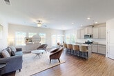 Located at 1240 Ohara Drive in Jonesboro, Georgia, this two-story home offers a thoughtfully designed layout spread across two levels. The main floor welcomes you with a wide hallway featuring hardwood-style flooring, an arched mirror, and a classic staircase with wood treads and black iron balusters that leads to the upper level. The open-concept living area flows seamlessly into the kitchen and dining room, bathed in natural light from multiple windows and French doors that open to the backyard. The kitchen is well-equipped with granite countertops, gray shaker-style cabinetry, stainless steel appliances including a refrigerator, range, and microwave, and a generous island with bar seating. The bright dining area features a chandelier and views of the fenced yard. A half bathroom with a pedestal sink completes the main floor. Upstairs, four bedrooms provide ample accommodation, with the primary bedroom offering a walk-in closet with wire shelving and carpet flooring. A dedicated laundry room with wire shelving and utility hookups adds convenience. Throughout, the home balances functional design with clean, neutral finishes, creating a bright and welcoming atmosphere.