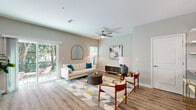 Located at 1201 Cleveland Ave in Wildwood, FL, this two-story home offers a well-organized layout spread across two floors. The main level features an open-plan kitchen and living room bathed in natural light, with sliding glass doors that connect to the outdoors. The kitchen is equipped with crisp white shaker cabinets, granite-look countertops, a classic subway tile backsplash, and stainless steel appliances. Light wood-look flooring flows through the main living areas, complementing the neutral color palette. A welcoming hallway with clean white walls leads further into the home. The living area benefits from a ceiling fan and abundant natural light. Upstairs, the primary bedroom is a comfortable retreat with plush carpet, a ceiling fan, and a walk-in closet fitted with wire shelving. Three full bathrooms serve the home, including one with a tiled tub-shower combination and granite vanity countertop. A dedicated office with carpet, a ceiling fan, and natural light from large windows provides a functional workspace. Two closets, a utility room, and an attached garage with an automatic opener round out the practical amenities of this well-appointed Wildwood residence.