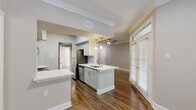 Located at 14885 Memorial Dr in Houston, TX, this well-appointed one-bedroom, one-bathroom unit offers a thoughtfully designed single-floor layout. Rich hardwood-style flooring flows throughout the main living areas, complemented by elegant crown molding and neutral-toned walls that create a clean, cohesive aesthetic.

The combined kitchen and living room serves as the heart of the unit. The kitchen is outfitted with stainless steel appliances, including a range, microwave, and refrigerator, along with white cabinetry, white quartz countertops, a peninsula with pendant lighting, and a undermount sink. The adjoining living area benefits from natural light through large windows with views of surrounding greenery, and is finished with a ceiling fan.

The bedroom is carpeted for comfort and features crown molding, a ceiling fan, and a window with outdoor views. It is serviced by two closets, one of which is a walk-in, offering generous storage. 

The full bathroom is elongated and well-lit, featuring a dual-sink vanity with white countertops, a shower-tub combination, and hardwood-style flooring. Louvered closet doors add a refined touch to the space. Overall, the unit combines functional design with modern finishes throughout.