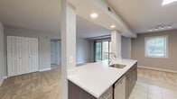 This contemporary 1-bedroom apartment offers 730 square feet of well-designed living space. The kitchen is a highlight, featuring sleek cabinetry in contrasting light and dark tones, stainless steel appliances, and ample counter space. The living area is spacious and bright, with plush carpeting and a sliding glass door leading to a private balcony, flooding the room with natural light. The bedroom is generously sized at 180 square feet, equipped with a ceiling fan and large windows. The bathroom showcases a modern design with a tiled shower/tub combination. Throughout the apartment, neutral tones create a calming atmosphere, while the open floor plan enhances the sense of space. Additional features include a walk-in closet with built-in organizers and in-unit laundry facilities. The apartment's layout is efficient, making excellent use of the available space and providing a comfortable, stylish home.