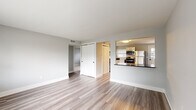 Located at 287 W Johnstown Rd in Gahanna, Ohio, this single-floor home offers a clean, modern aesthetic throughout its thoughtfully updated interior. The open living area is finished with light-toned luxury vinyl plank flooring and soft gray walls, creating a bright and welcoming atmosphere enhanced by a large front-facing window that draws in natural light. A built-in closet provides convenient storage directly off the living space.

The kitchen is a standout feature, boasting white shaker-style cabinetry, dark granite countertops, a classic subway tile backsplash, and a full suite of stainless steel appliances including a refrigerator, range, over-the-range microwave, and dishwasher. The kitchen opens to the living area via a raised bar counter, promoting an easy flow between spaces. An adjacent utility area accommodates a washer and dryer, adding practical convenience.

The bedrooms are carpeted for comfort and feature dual windows that flood each room with natural light and views of the surrounding neighborhood. The bathroom is finished in a crisp, all-white palette with wood-look flooring, a tub/shower combo, a white vanity, and sleek matte black hardware accents. Throughout the home, consistent gray wall tones and white trim tie the design together cohesively.