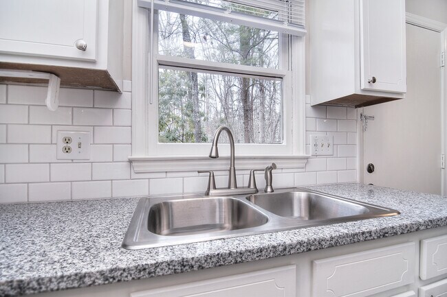 El fregadero de la cocina tiene vistas a una zona boscosa. - 339 Sunny Hill Dr