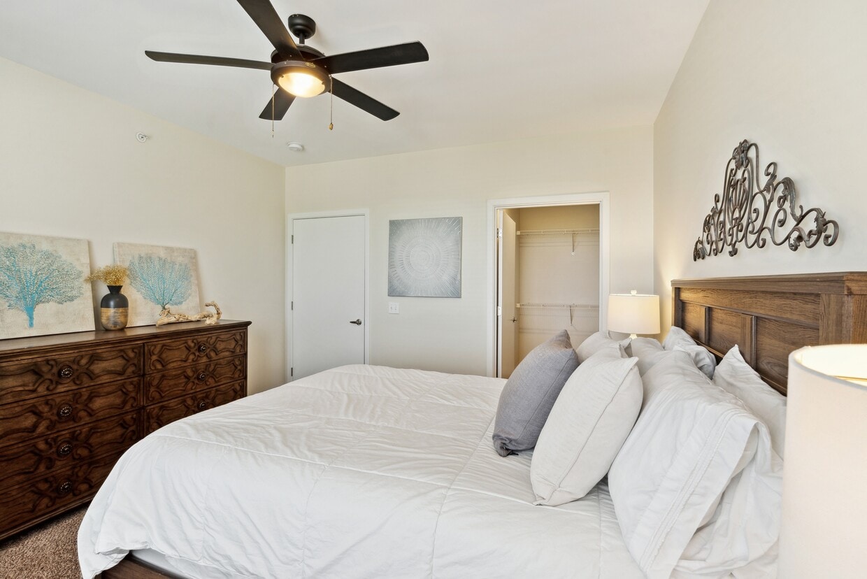 Carpeted Bedroom w/ Ceiling Fan - Waterside at River Park Apartments