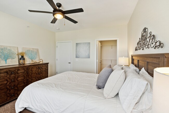 Carpeted Bedroom w/ Ceiling Fan - Waterside at River Park Apartments