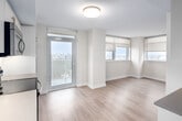 Located on the 19th floor at 118 Balliol Street in Toronto's midtown neighbourhood, this two-bedroom, two-bathroom unit offers a efficiently designed layout across a single floor. Light wood laminate flooring runs throughout the living areas and bedrooms, contributing to a cohesive, contemporary aesthetic.

The kitchen is well-appointed with stainless steel appliances, including a full-size refrigerator, electric range, built-in microwave, and dishwasher. White cabinetry extends to the ceiling, maximizing storage, while under-cabinet lighting illuminates the countertops. A sliding glass door in the kitchen provides direct access to a balcony, allowing natural light to flow into the space.

The primary bedroom features a sliding mirrored closet door and connects to the hallway, which is lined with additional mirrored storage. The second bedroom includes its own balcony access via a sliding door, bringing in additional natural light. Both rooms are finished with clean white walls and recessed lighting.

The two bathrooms are finished in white tile and feature modern fixtures. One includes a soaker tub with a tiled surround, while the other offers a glass-enclosed walk-in shower. Both are equipped with vanities featuring grey countertops and brushed nickel hardware, maintaining a consistent, clean design throughout.