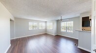 Located at 1724 Ontario Ave in Naperville, Illinois, this one-bedroom, one-bathroom single-floor unit offers a well-designed layout with a comfortable and functional living environment. Rich, dark hardwood flooring flows through the living room, kitchen, and hallway, providing a warm and cohesive aesthetic throughout the main areas.

The spacious living room is a standout feature, lined with multiple windows fitted with white plantation shutters that invite generous natural light and offer outdoor views. A ceiling fan adds comfort and a subtle design detail to the textured ceiling above.

The kitchen is thoughtfully appointed with dark espresso cabinetry, granite countertops, stainless steel appliances, and a distinctive arched window above the sink that brings in additional light. The hardwood flooring continues seamlessly into this space, reinforcing the unit's consistent style.

The bedroom is a comfortable retreat, carpeted for added softness and warmth, and includes a window with outdoor views as well as a closet. Neutral gray walls throughout the unit complement both the flooring and fixtures.

The bathroom features a full tub-shower combination with white tile surround, stone-look tile flooring, and brushed nickel fixtures and hardware. A hallway connects all areas efficiently, completing this well-organized and move-in-ready unit.