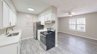 This well-designed 540 square foot apartment in North Charleston offers a practical and contemporary living space. The single-story layout comprises one bedroom, one bathroom, a kitchen, and additional living areas. The property showcases a neutral color scheme with beige walls and modern gray wood-look flooring throughout, creating a cohesive and spacious feel.

The bedroom, measuring 150 square feet, features a large window with white blinds, allowing ample natural light. The updated kitchen boasts white cabinetry, a stainless steel refrigerator, and a modern electric range. The efficient design includes ample counter space and overhead cabinets for storage.

The bathroom is equipped with a white bathtub-shower combination, featuring a built-in shelf and a curved shower rod. The living areas are illuminated by recessed lighting and a ceiling fan, enhancing the overall ambiance. The property's efficient use of space is evident in the 3D floor plan, which reveals a well-organized layout with a hallway and closet space.

Located at 2561 Fassitt Rd in North Charleston, SC, this apartment offers a blend of functionality and style, ideal for those seeking a compact yet comfortable living space.