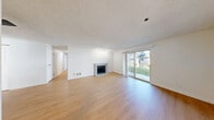 Located at 4600 Davis Ave S in Renton, WA, this single-floor, 3-bedroom, 3-bathroom home offers a practical and well-appointed layout. The combined living and dining area serves as the heart of the home, featuring warm luxury vinyl plank flooring, a textured ceiling, a fireplace, and sliding glass doors that open to a private patio with outdoor views. The galley-style kitchen is outfitted with white cabinetry with matte black hardware, stone-look countertops, stainless steel appliances including a refrigerator and dishwasher, and a window above the sink for natural light. A half-wall peninsula connects the kitchen to the dining area, enhancing the open feel. The three bedrooms feature plush carpeting, natural light from windows, and generous closet space with sliding doors. Five closets throughout the home provide abundant storage. The three bathrooms are clean and functional, each featuring a full tub-shower combination with chrome fixtures. Additional highlights include an in-unit laundry room and a connecting hallway that ties the layout together efficiently. The home's bright, neutral palette and consistent flooring create a cohesive and move-in-ready atmosphere throughout.