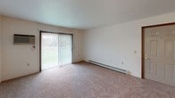 Located at 15881 McClellan Dr in Marshall, Michigan, this single-floor unit offers a practical and comfortable layout designed for everyday living. The spacious living area is finished with neutral carpet and features large windows that allow generous natural light to fill the room, along with a ceiling fan for added comfort. A sliding glass door opens to a view of the surrounding greenery, bringing the outdoors in and creating a bright, airy atmosphere. Baseboard heating runs throughout the unit, providing consistent warmth across all rooms.

The galley-style kitchen is efficiently organized with white cabinetry trimmed in warm wood tones, ample counter space, a stainless steel sink, and wood-look flooring that contrasts neatly with the lighter cabinetry. Appliances including a refrigerator and dishwasher are included.

The bedrooms are carpeted and well-sized, each offering closet storage and windows with blinds for privacy. Warm wood-toned doors and trim carry a consistent design language throughout the unit. The bathroom is clean and functional, featuring wood-look flooring, a vanity, and baseboard heating.

The floor plan flows logically from the living and dining areas into the kitchen and private sleeping quarters, making the layout both intuitive and efficient for daily use.