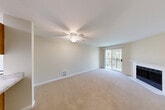 Located at 10710 Evergreen Way in Everett, WA, this one-bedroom, two-bathroom residence offers a well-organized single-floor layout designed for comfortable everyday living. The living room serves as the centerpiece of the home, featuring plush wall-to-wall carpeting, a ceiling fan with light fixture, and a classic fireplace. A sliding glass door opens to a private balcony overlooking lush, mature trees, bringing in natural light and serene outdoor views. An open pass-through connects the living area to the kitchen, which features warm wood-toned cabinetry and a light countertop. The hallway transitions to wood-look plank flooring and provides access to the bedroom and bathrooms. The spacious primary bedroom offers generous closet space with sliding double doors, soft carpeting, and a window framing tranquil tree views. The bathrooms are cleanly finished, with one featuring a full tub-shower combination, chrome fixtures, wood-look flooring, and a stone-patterned vanity countertop. Neutral wall tones and consistent finishes throughout the home create a cohesive, move-in-ready atmosphere suited for a variety of lifestyles.